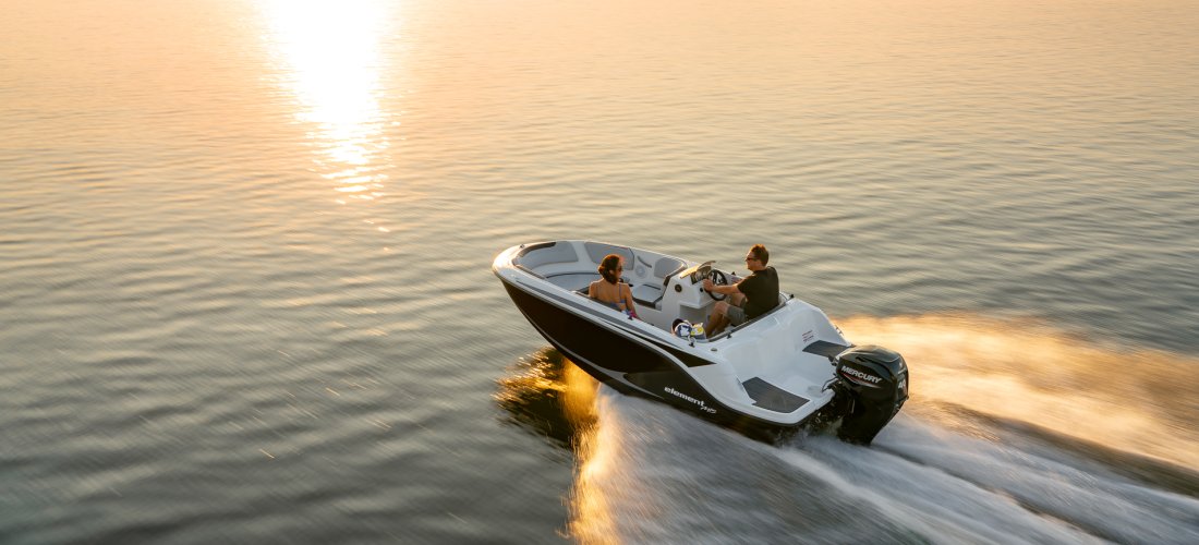 Bayliner M15 med 40 hk Mercury påhængsmotor på vandet i solnedgang.